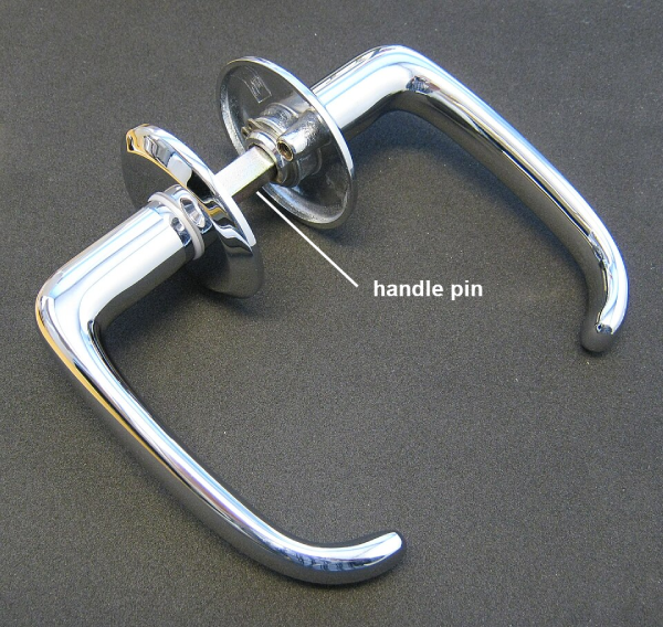 A square-shaped handle pin, also known as a square pin, connects a pair of door handles with attached rosettes.